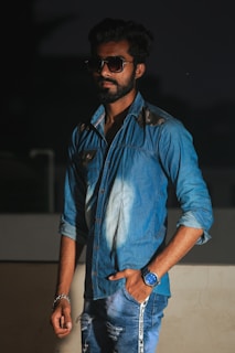 A stylish man wearing casual denim in a luxury café setting.