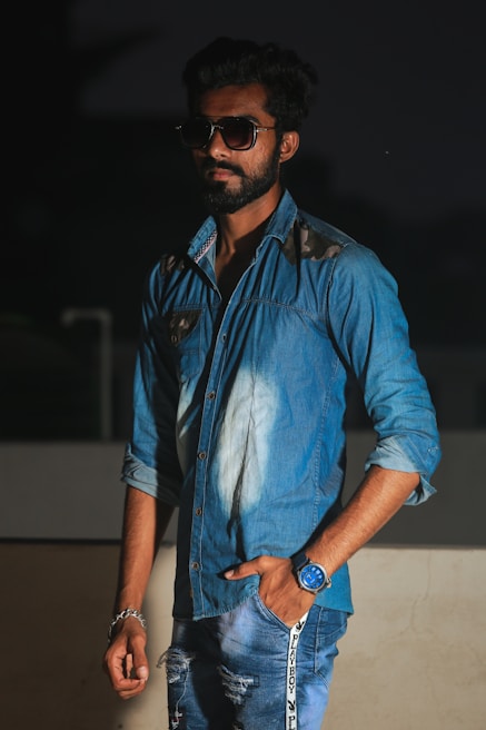 A stylish man wearing casual denim in a luxury café setting.