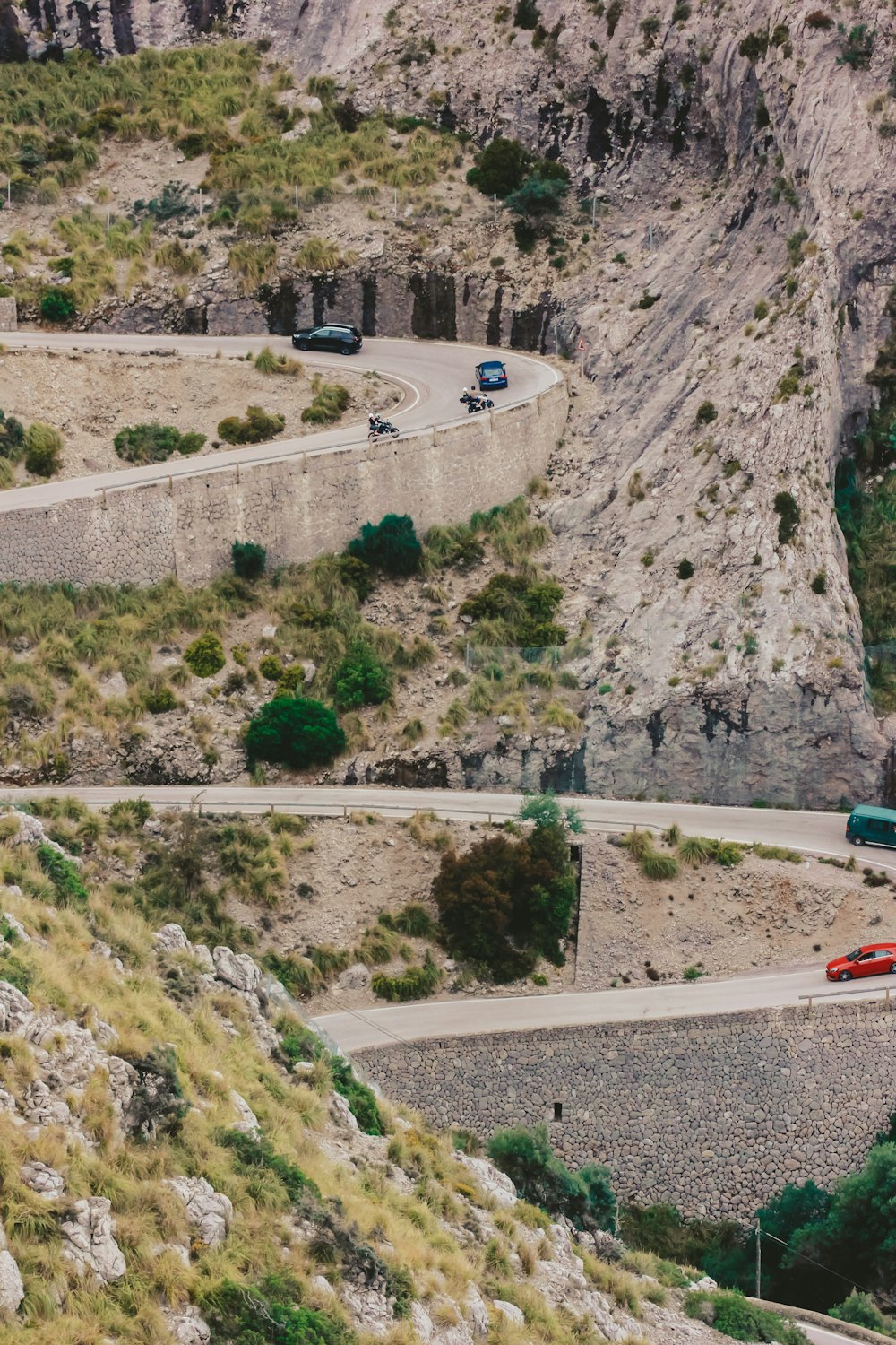 a red bus driving down a winding road