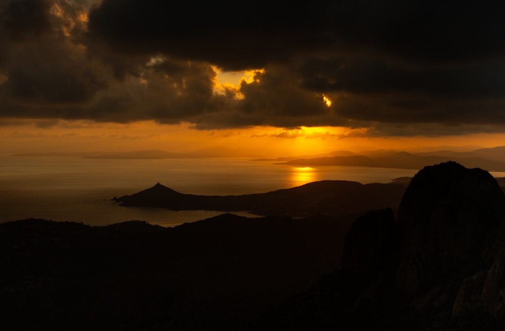 the sun is setting over a mountain range