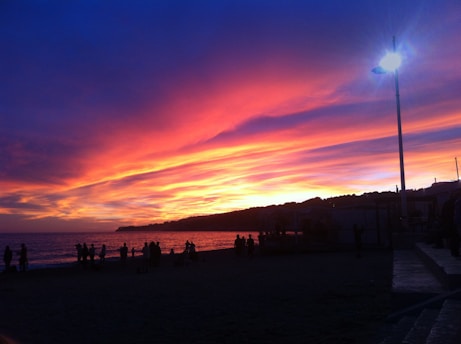 A vibrant photo of tourists enjoying the sunset at Cabo Branco beach in João Pessoa.