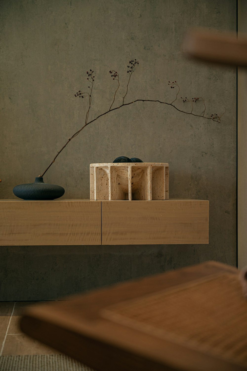 a vase sitting on top of a wooden shelf