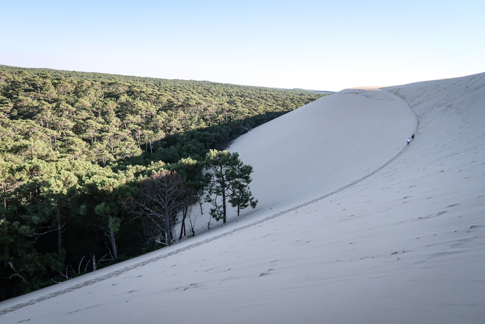 a person riding a snowboard down the side of a snow covered slope