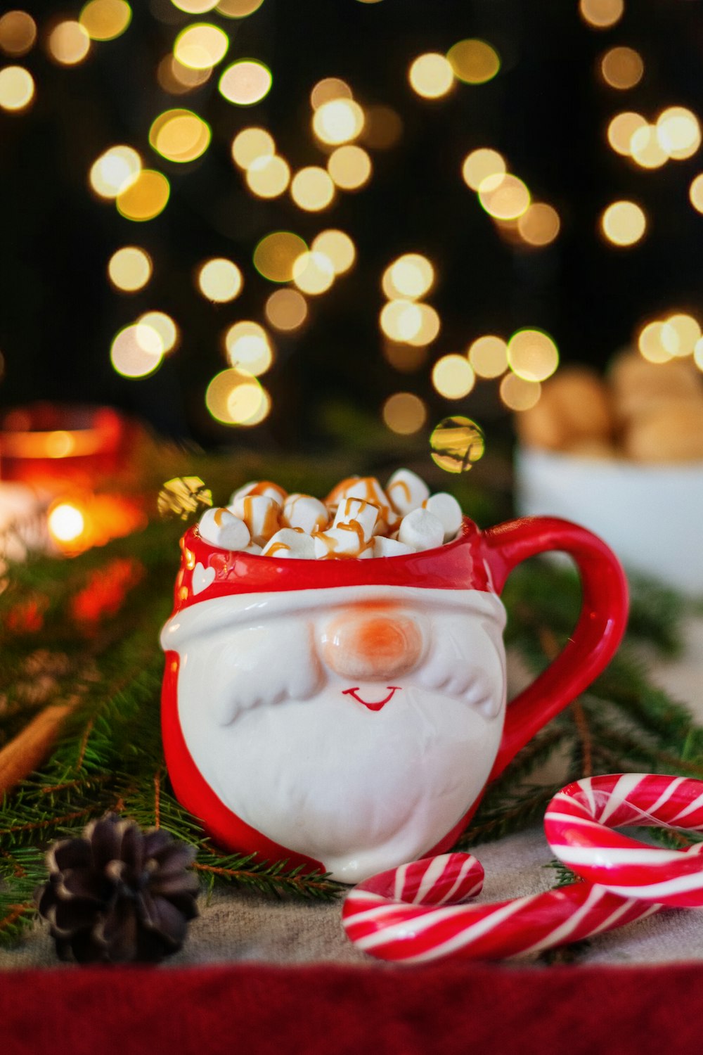 uma xícara de chocolate quente com marshmallows e bengalas de doces