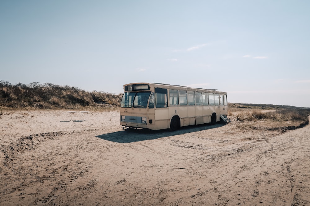 a bus parked on the side of a dirt road