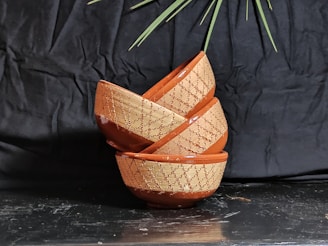 Stacked plastic bowls in warm beige and olive green shades, highlighting their smooth texture.