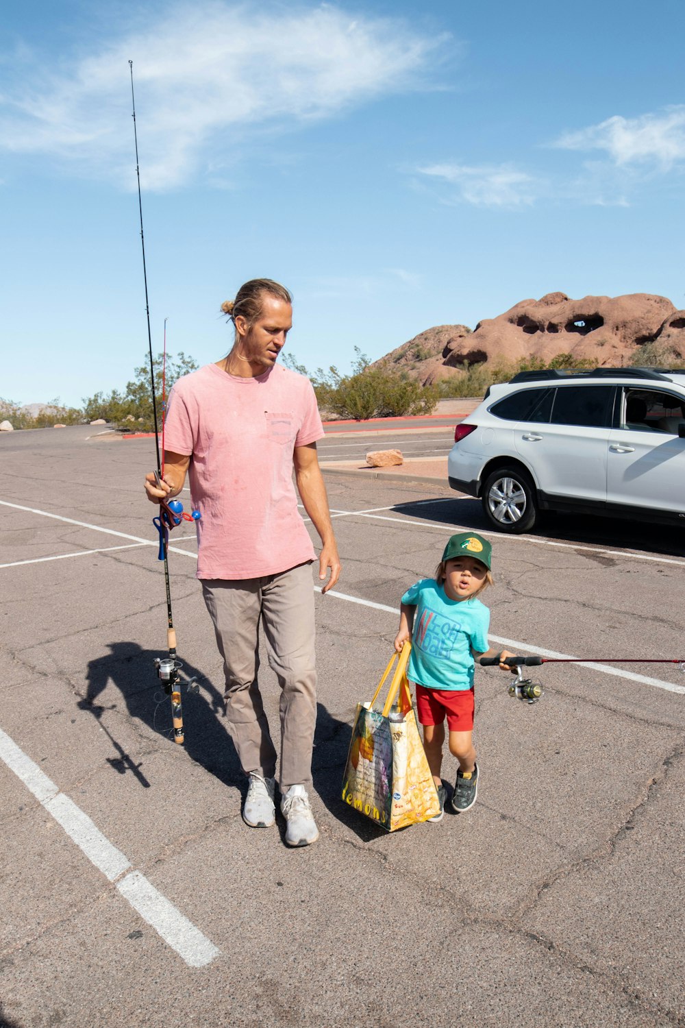 a man and a child are walking in a parking lot