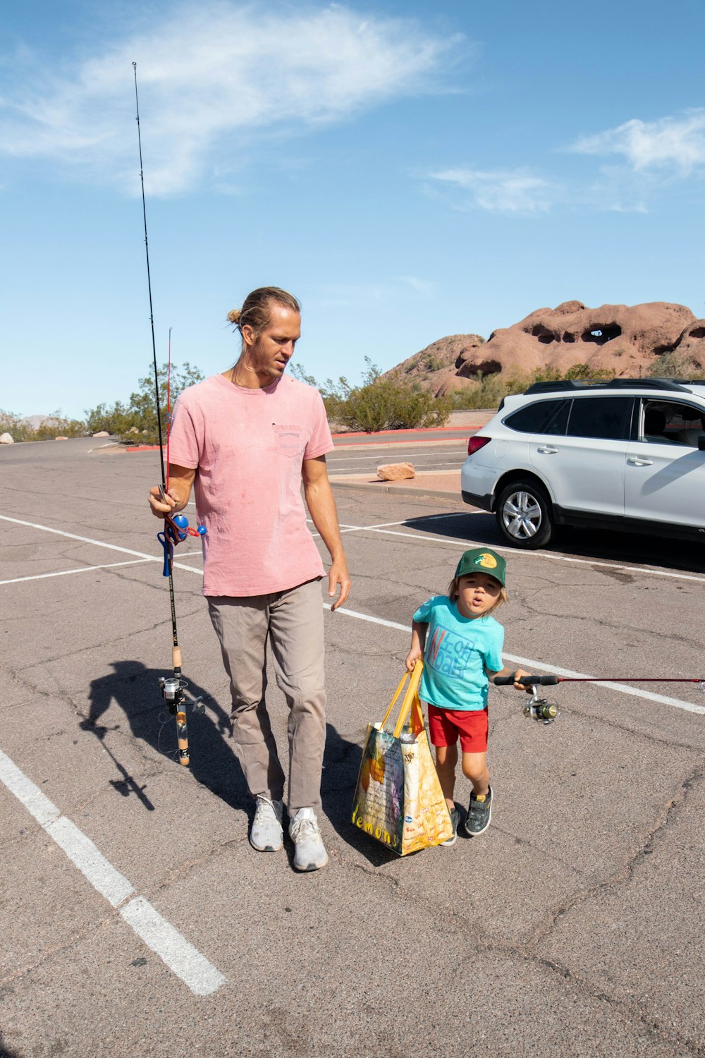 Un hombre y un niño caminan en un estacionamiento