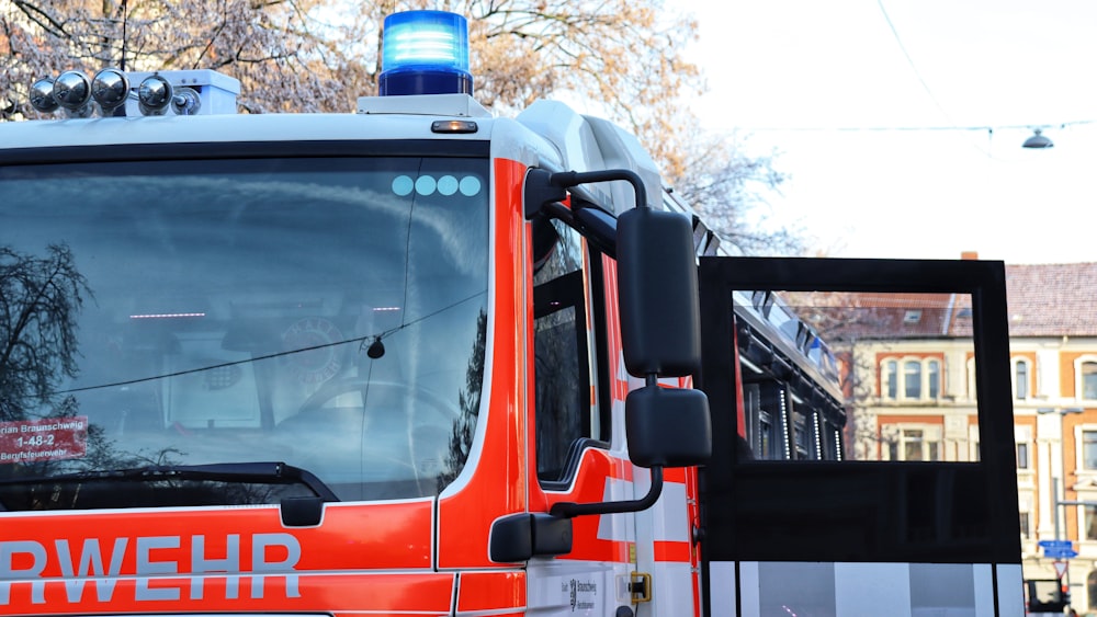 an orange and white bus driving down a street