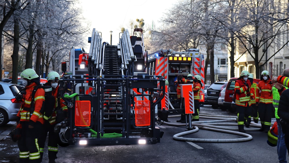 a group of fire fighters standing around a fire truck