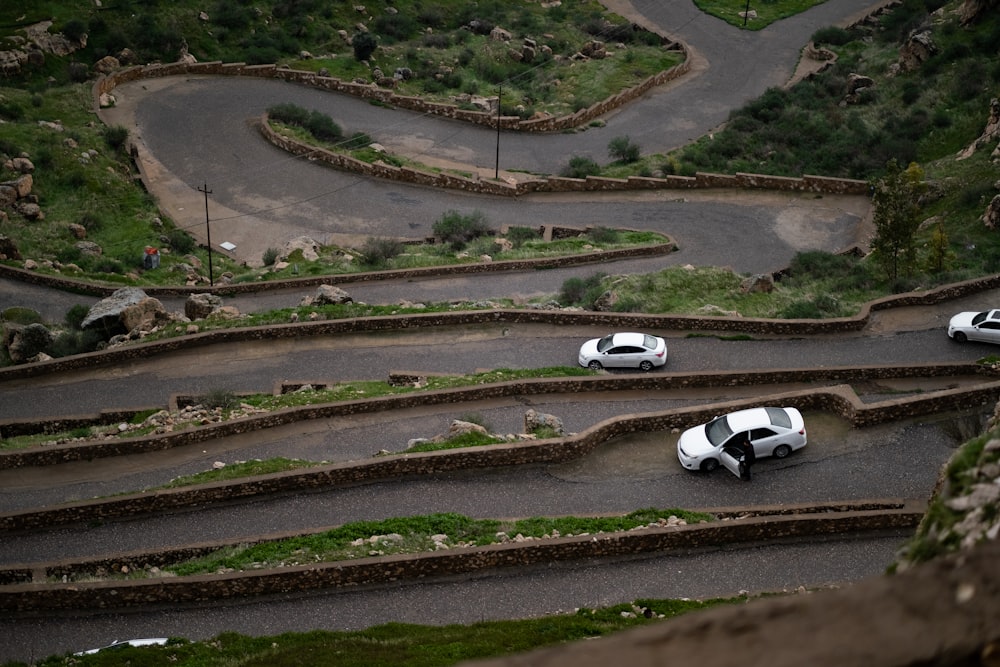 a group of cars driving down a winding road