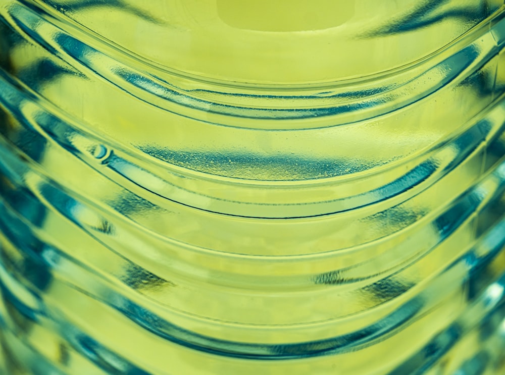 a close up of a yellow vase filled with water