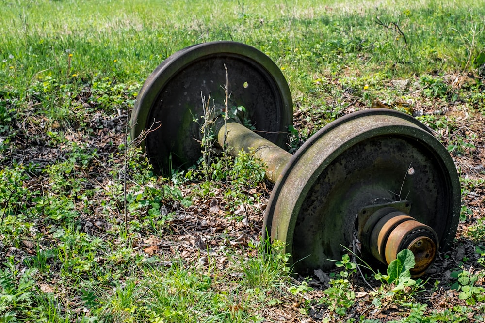 a couple of metal wheels sitting in the grass