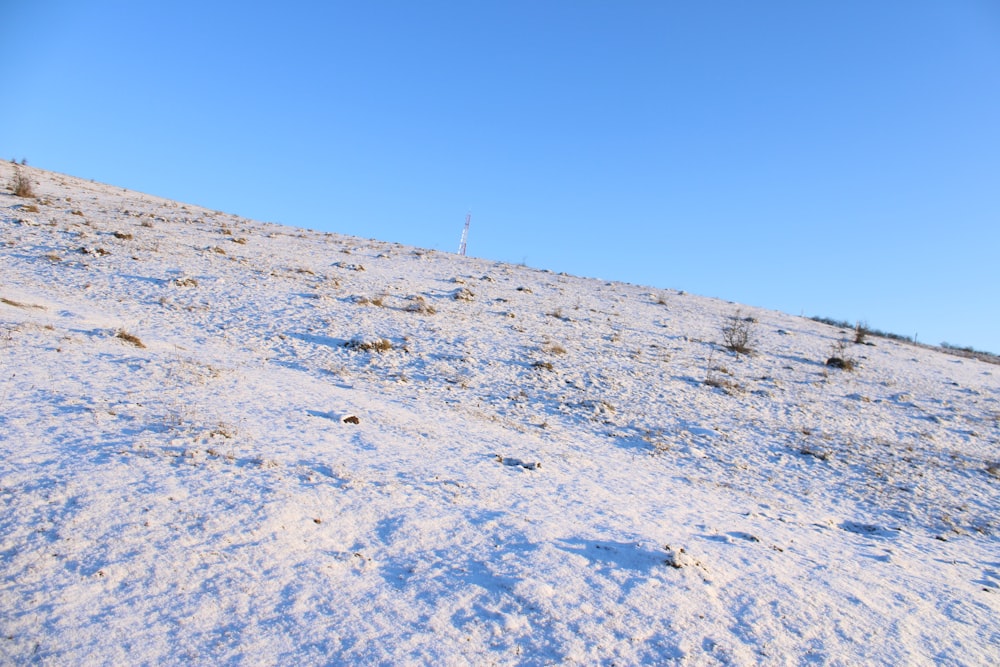 a person riding a snowboard down a snow covered slope