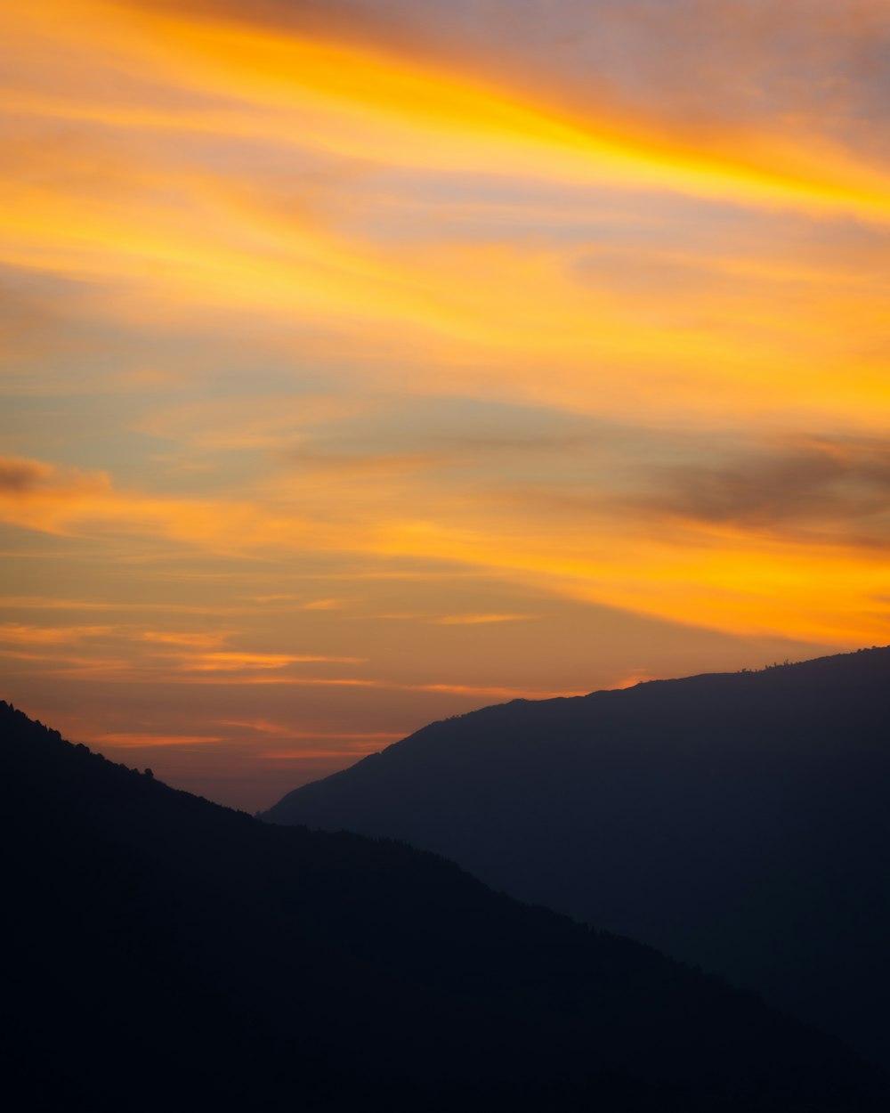 a plane flying in the sky at sunset