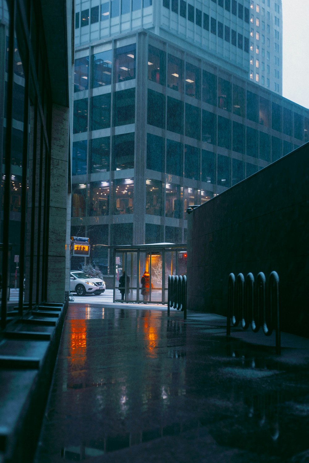 a person walking down a sidewalk in the rain
