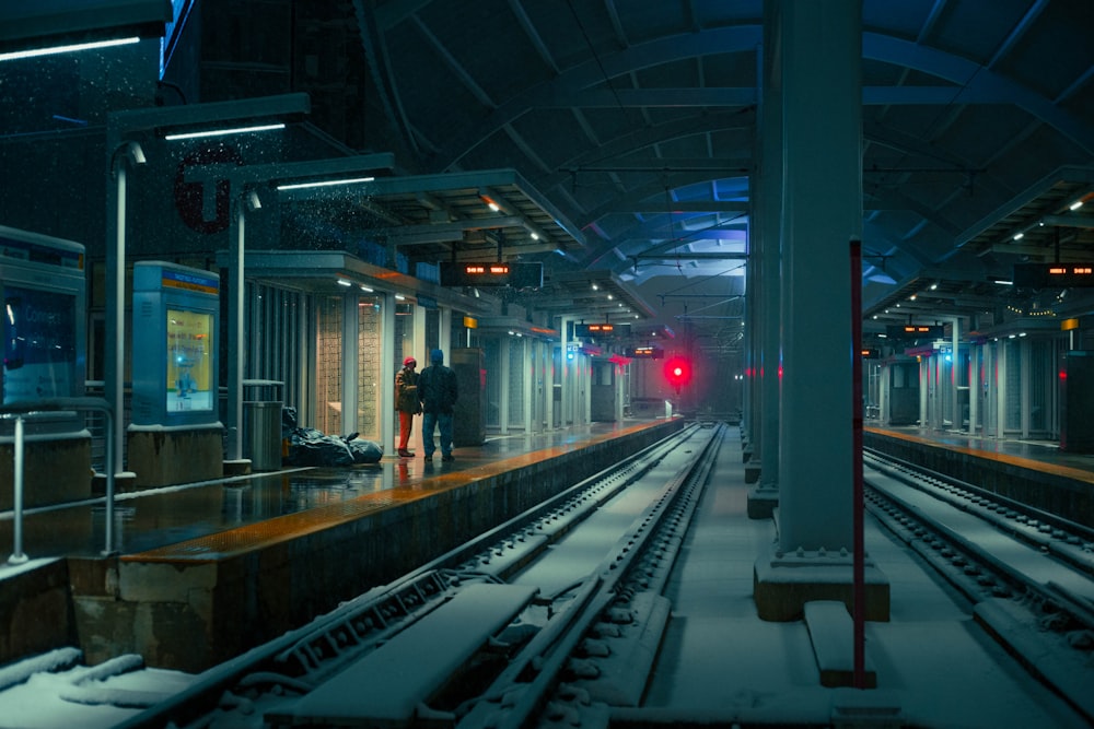 a train station with tracks covered in snow