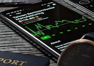 a passport, cell phone, watch and wallet on a table