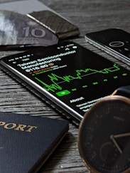 a passport, cell phone, watch and wallet on a table