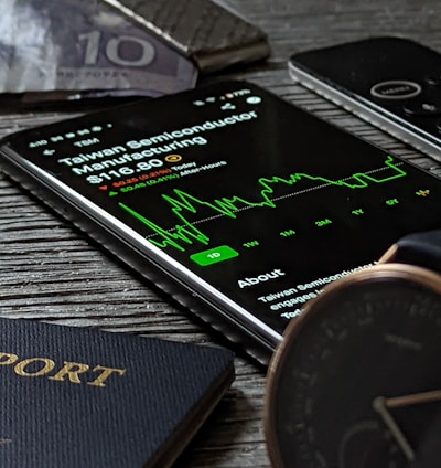 a passport, cell phone, watch and wallet on a table