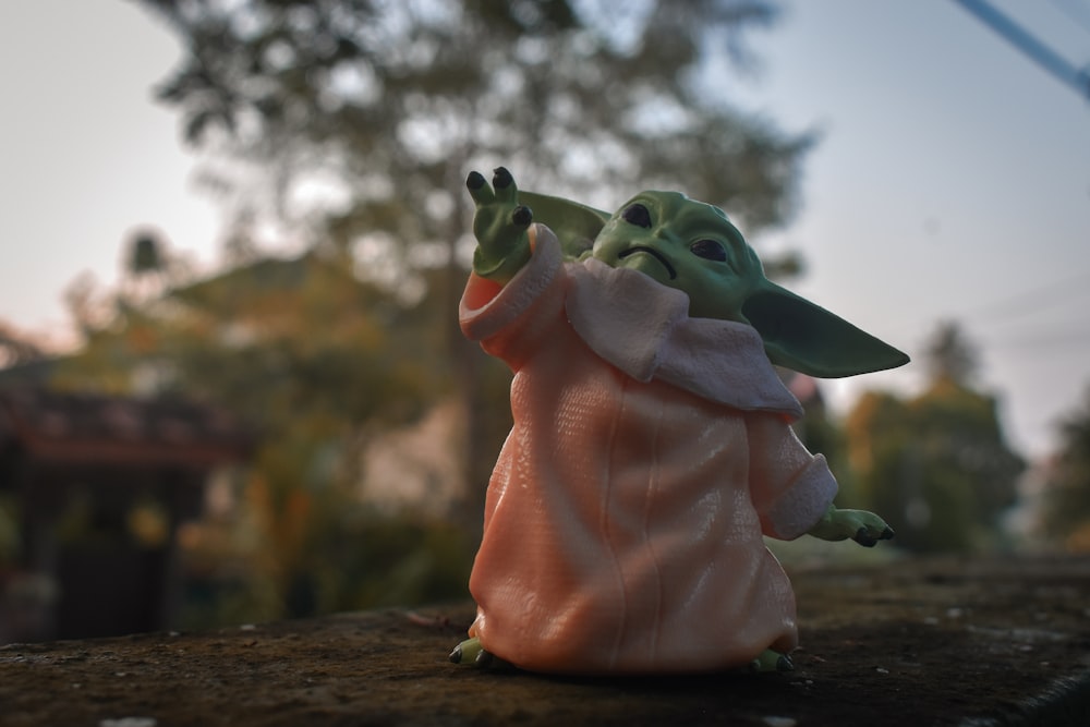 Ein Spielzeug eines Baby-Yoda, der auf etwas zeigt