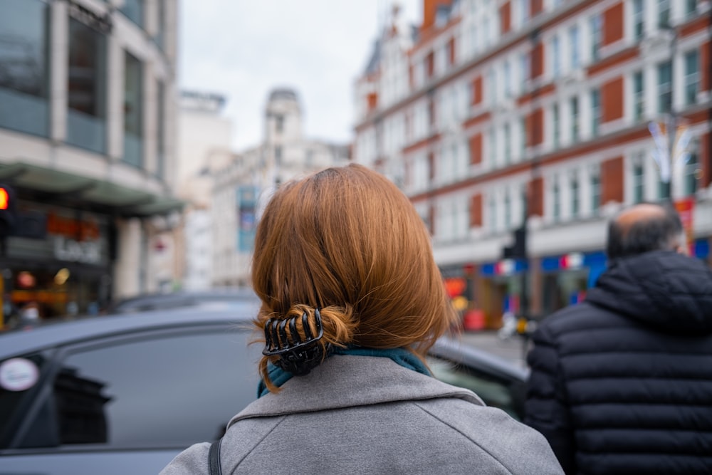 a woman with red hair walking down the street