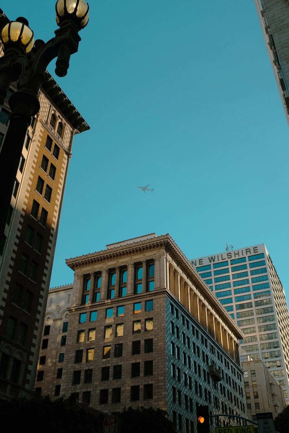 a plane flying in the sky over some buildings