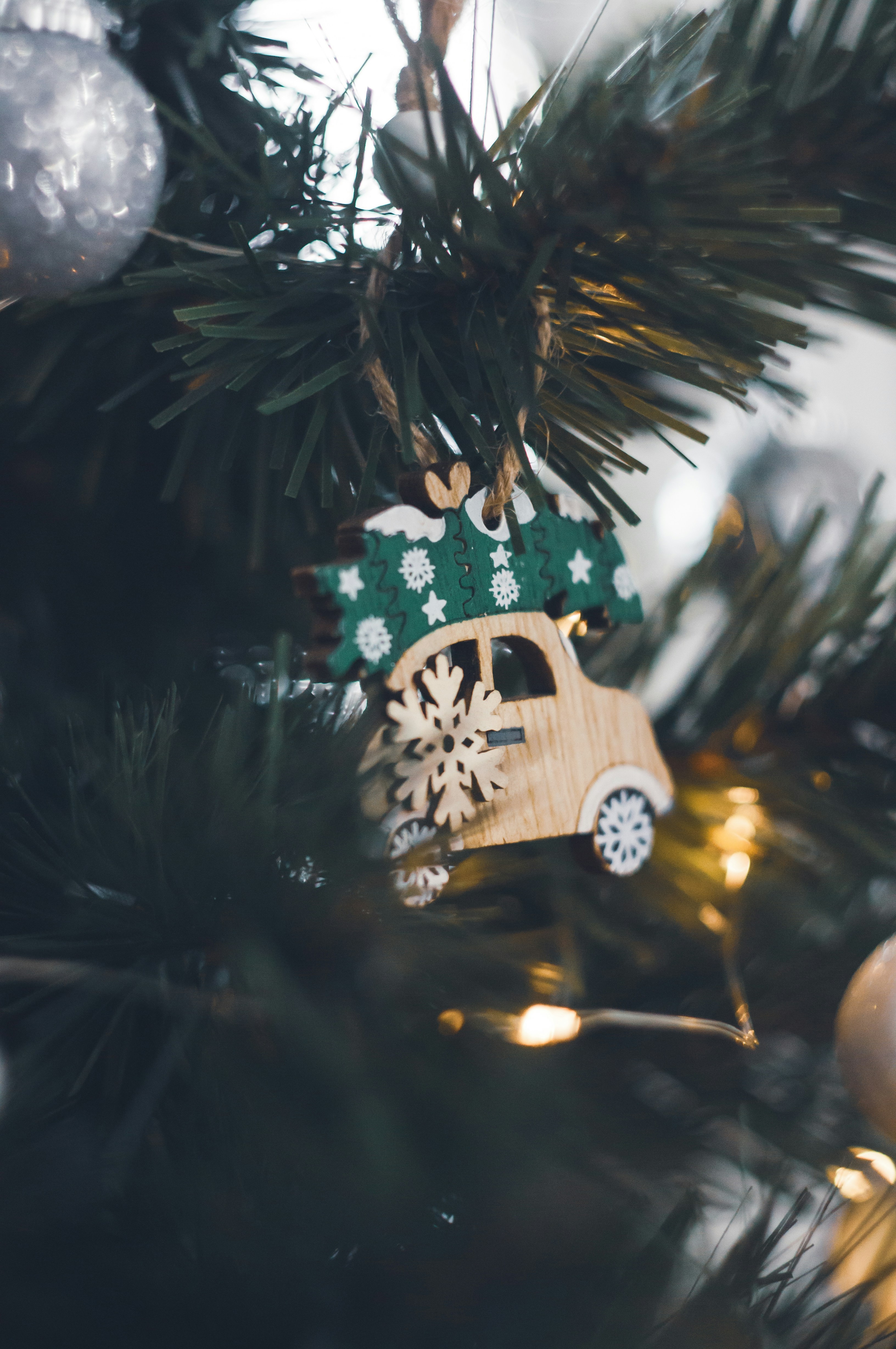 a wooden car ornament hanging from a christmas tree