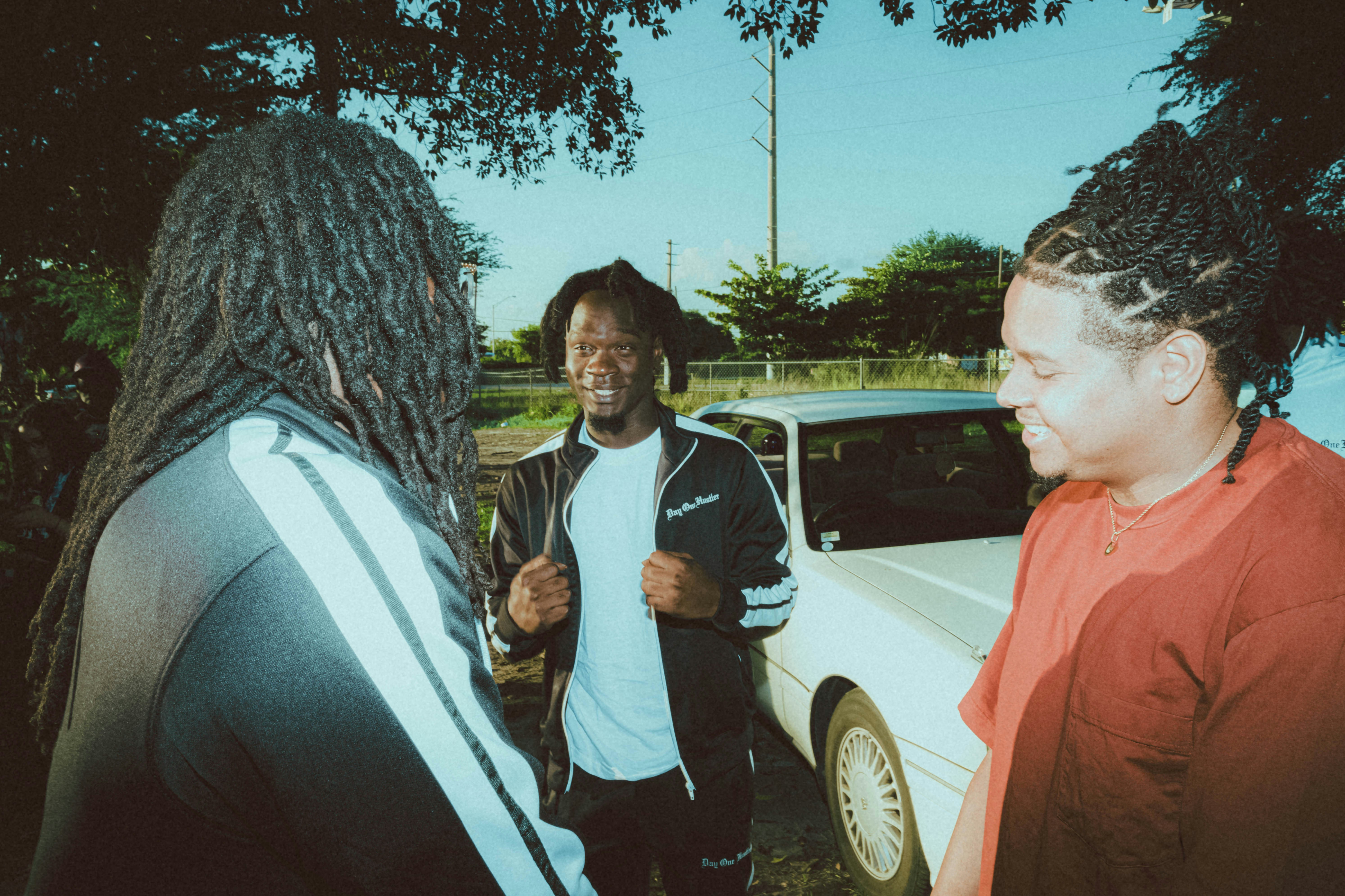 a group of people standing around a white car