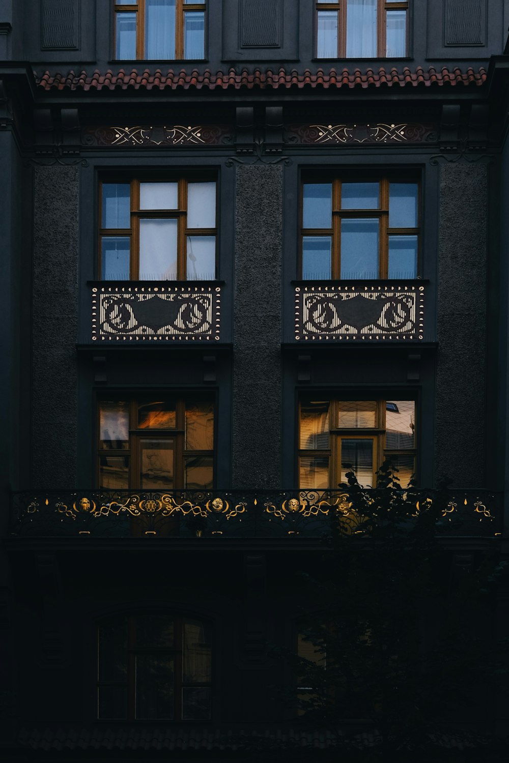 Ein schwarzes Gebäude mit Fenstern und einem Balkon