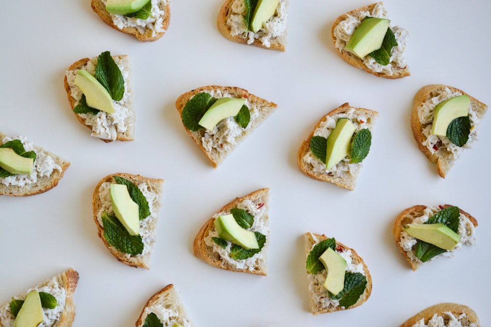 a white plate topped with slices of bread covered in cheese and veggies