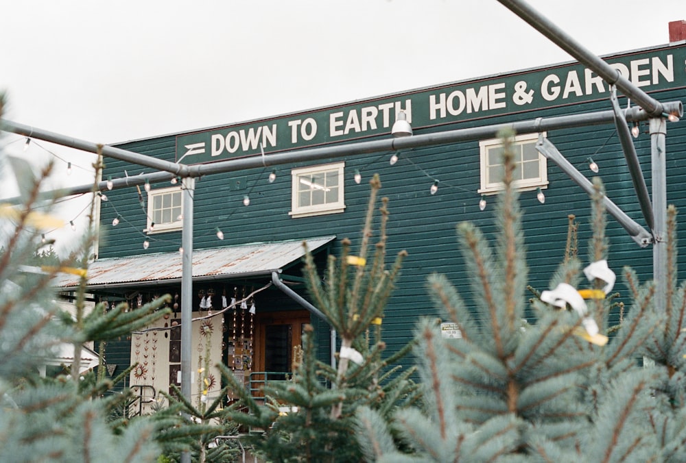 地に足の着いた家と庭と書かれた看板のある緑の建物
