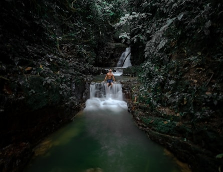 a man sitting on top of a waterfall