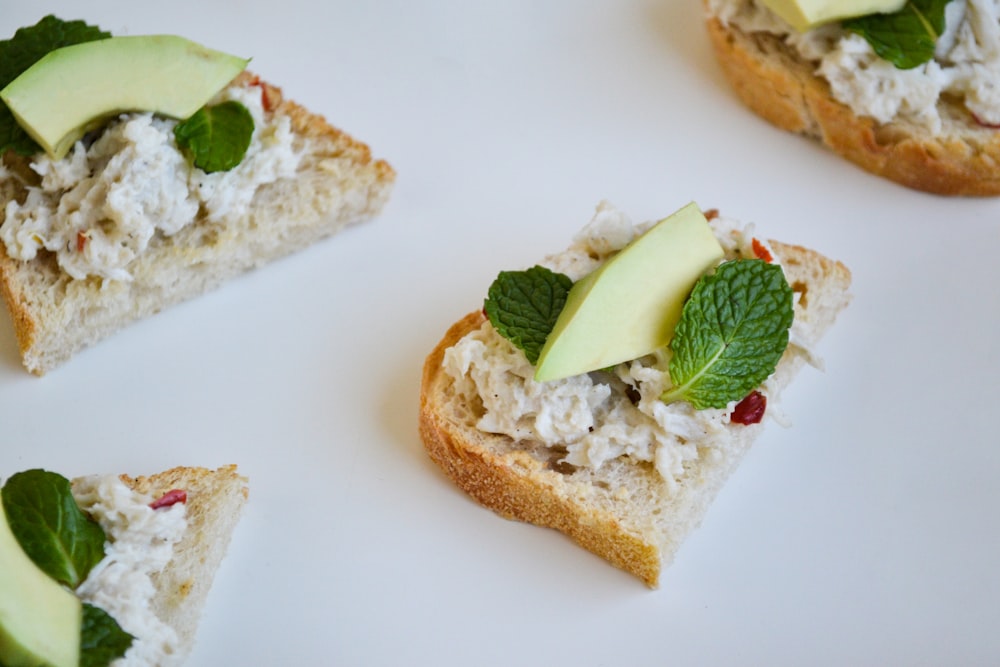 a white plate topped with slices of bread and veggies