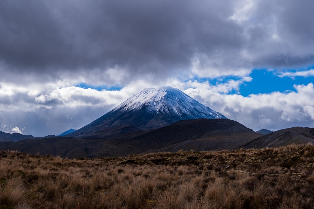 a snow covered mountain in the distance under a cloudy sky