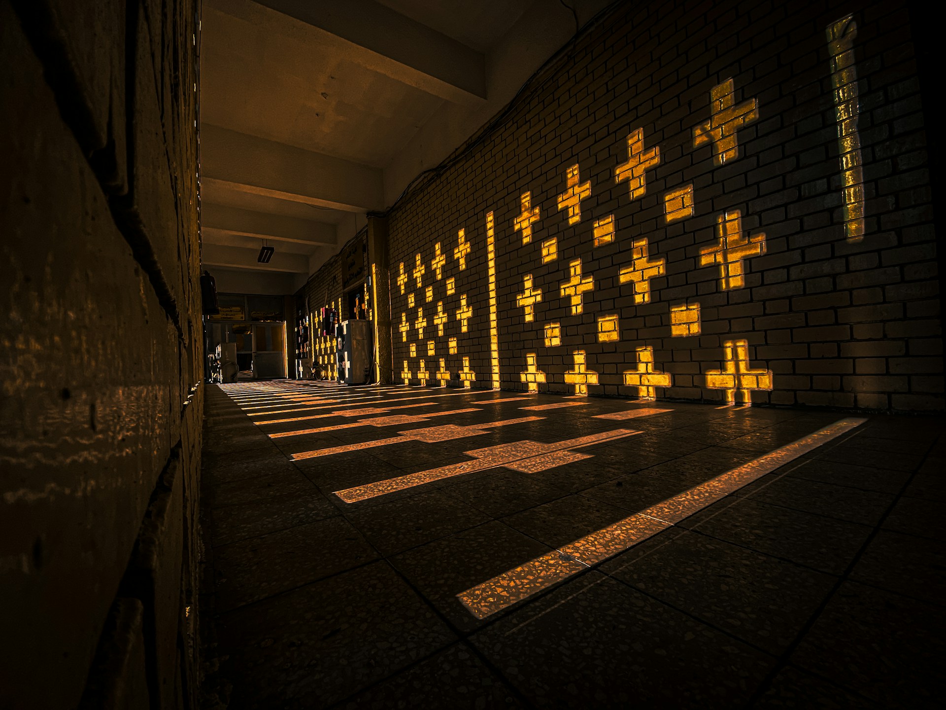 a room with a brick wall and yellow crosses on it