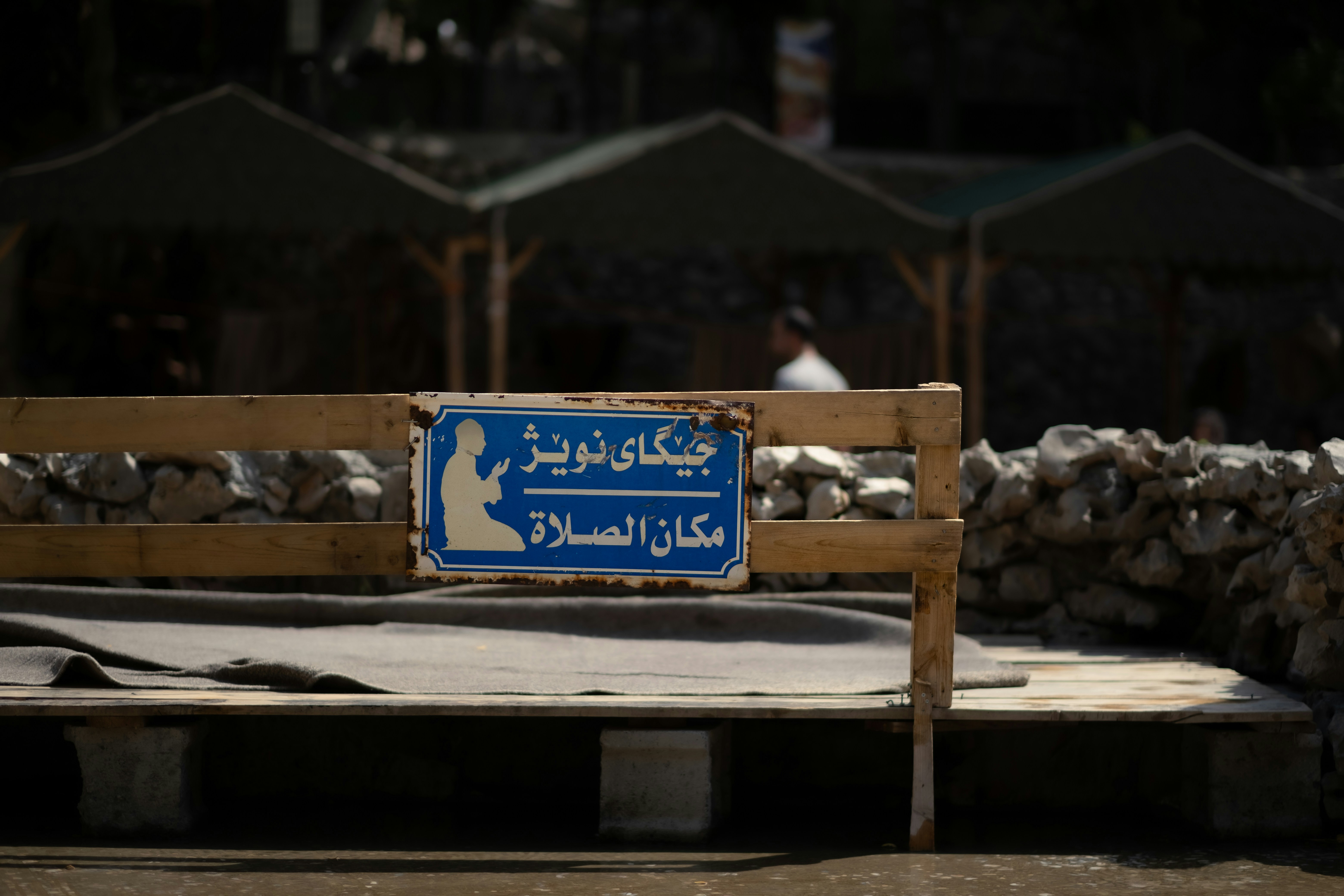a blue sign sitting on top of a wooden bench