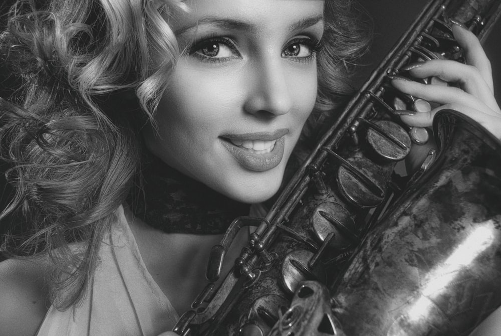 a woman holding a saxophone in her right hand