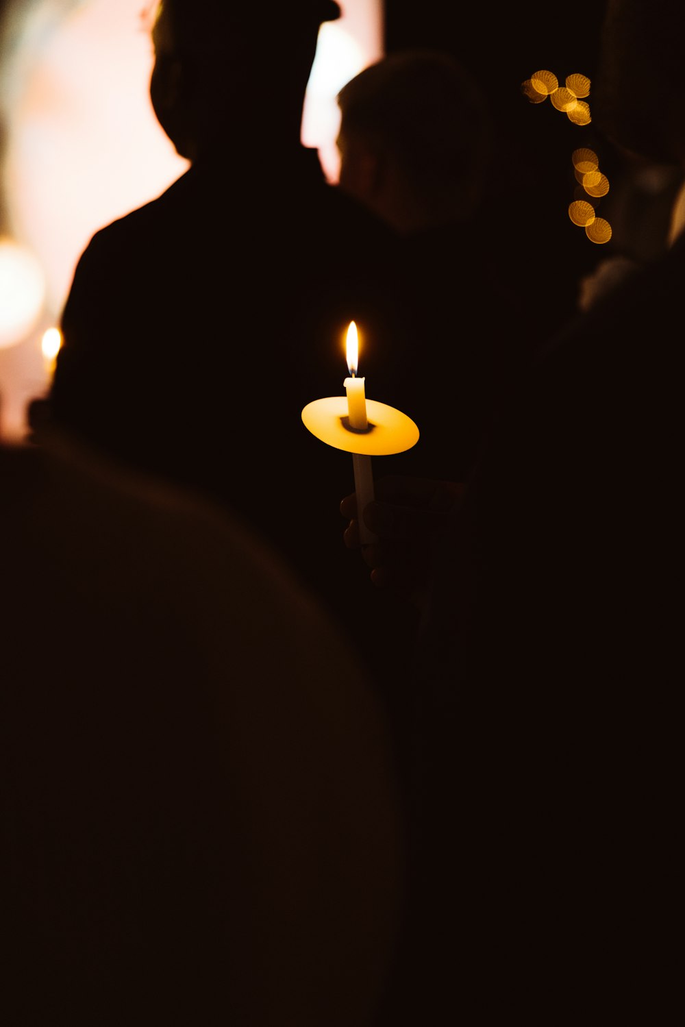 a person holding a lit candle in their hand