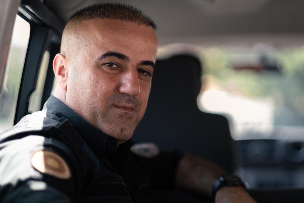 a police officer sitting in the back seat of a car