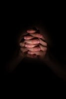 a person holding their hands together in the dark