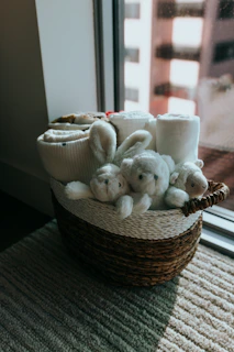a basket filled with stuffed animals next to a window