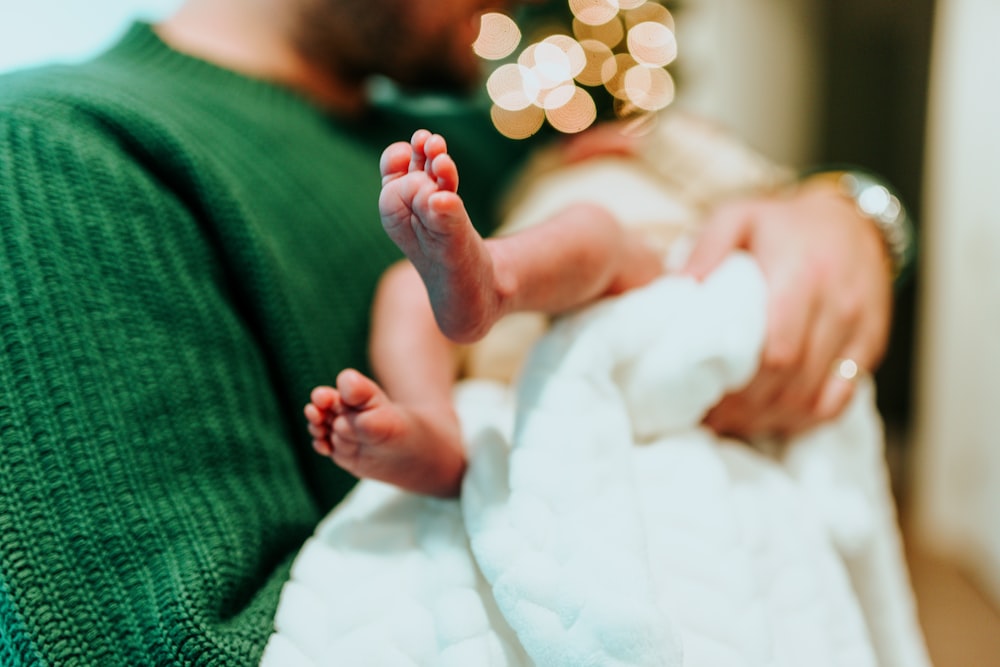 a close up of a person holding a baby