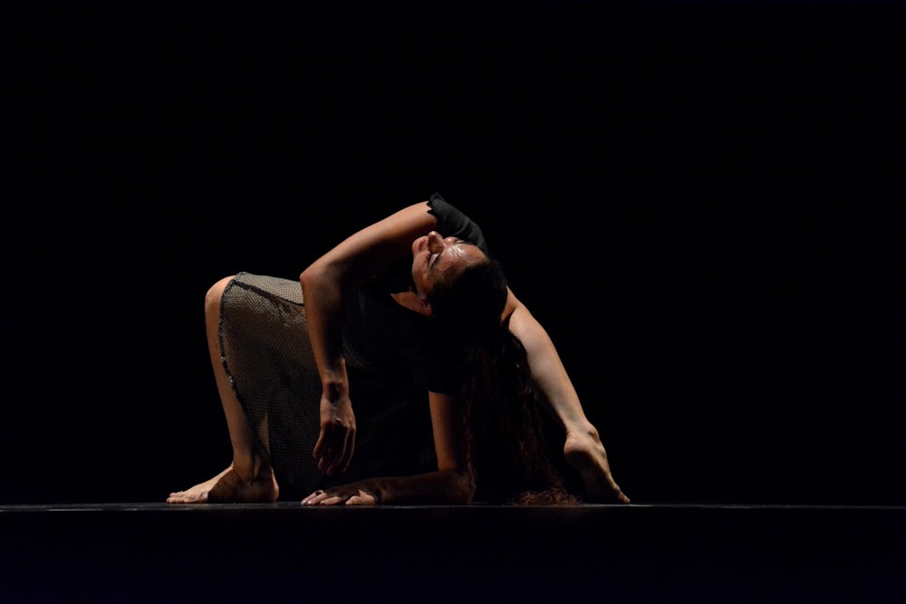 a woman in a black shirt is doing a handstand