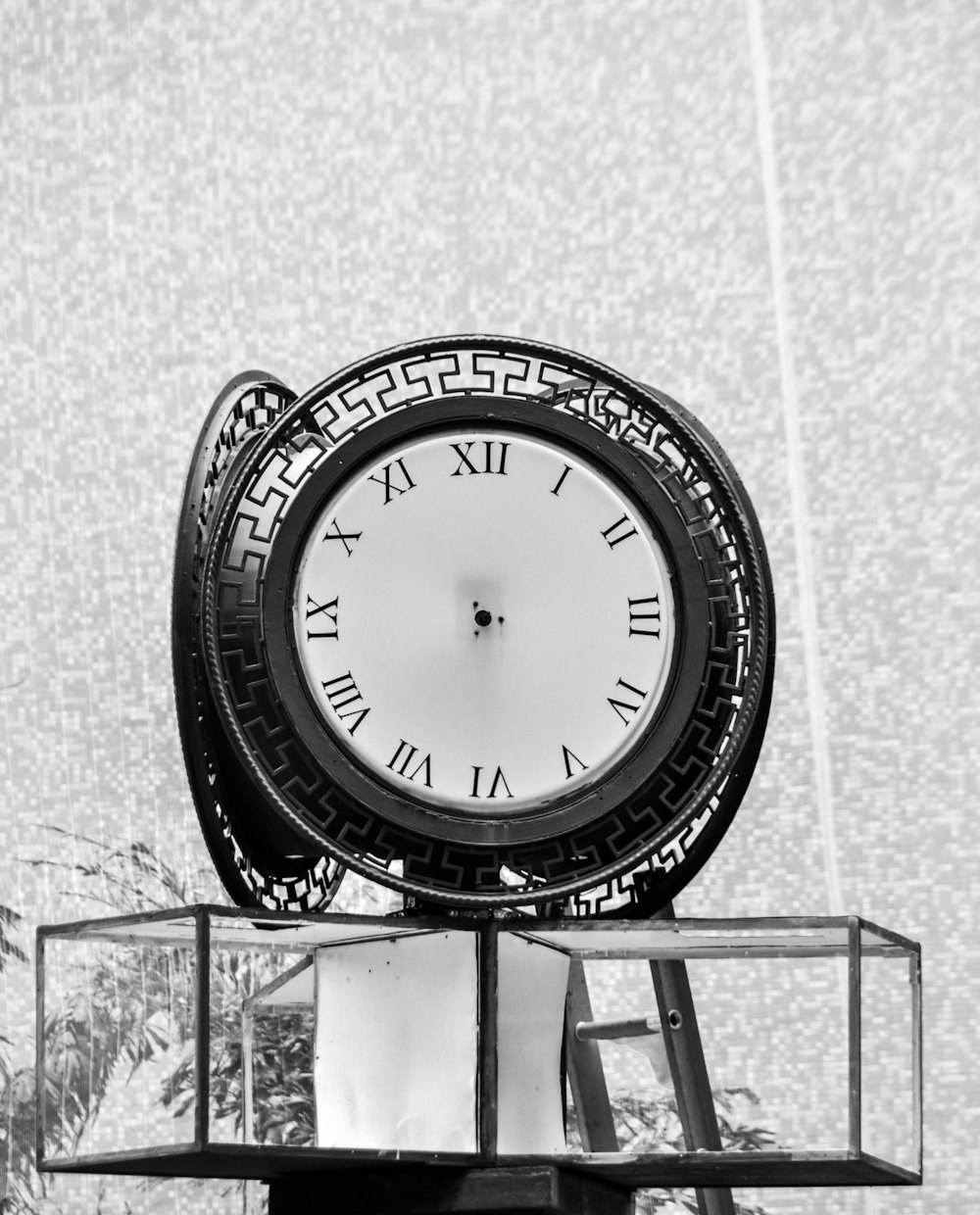 Una foto in bianco e nero di un orologio in cima a un edificio
