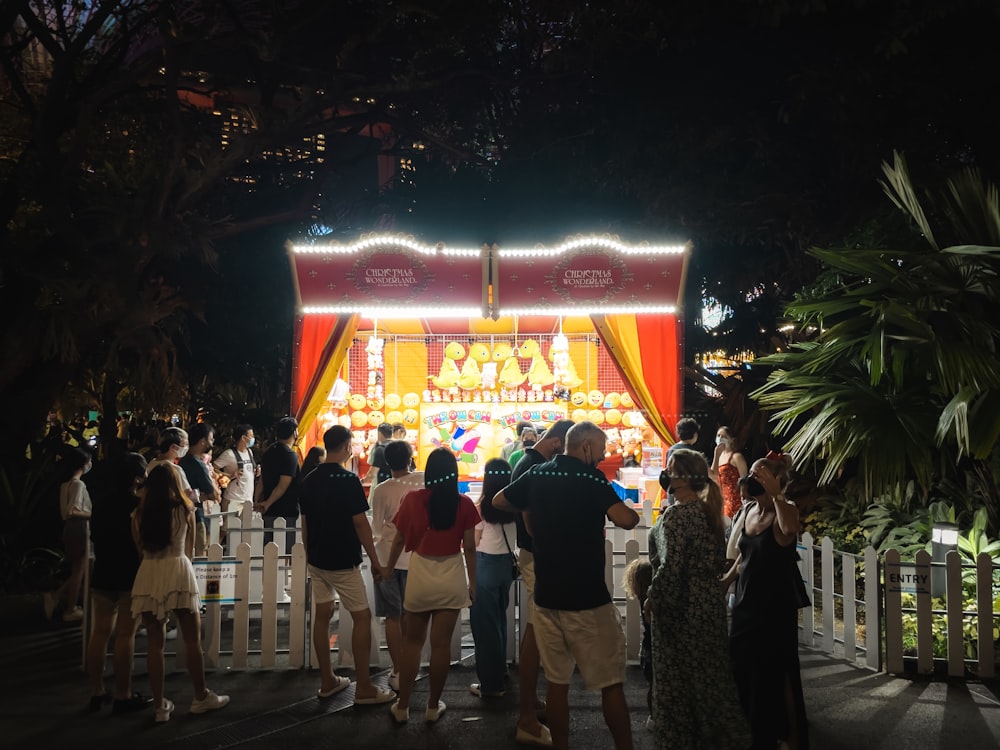 a group of people standing around a carnival ride