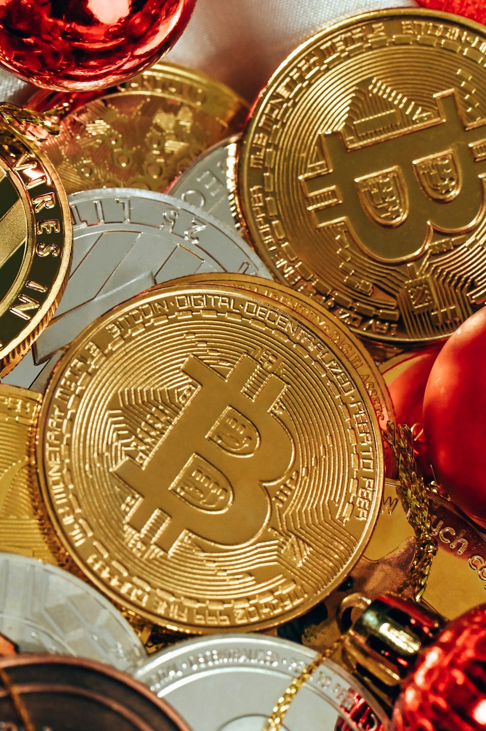 Una pila de bitcoins de oro junto a una copa de vino