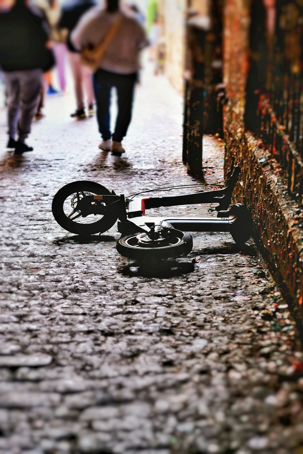 a broken bike laying on the ground in the middle of a street