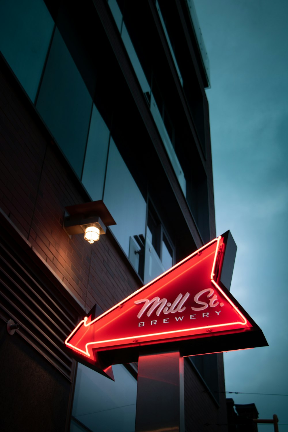 a red neon sign hanging from the side of a building