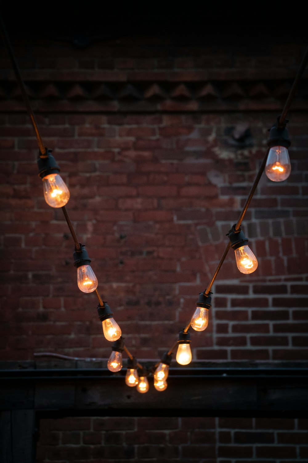 a string of light bulbs hanging from a brick wall